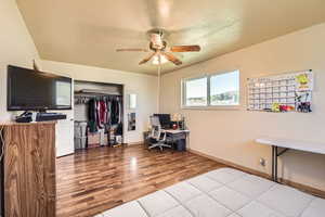 Office with wood finished floors, a ceiling fan, and baseboards