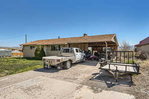 Back of house featuring a carport and concrete driveway