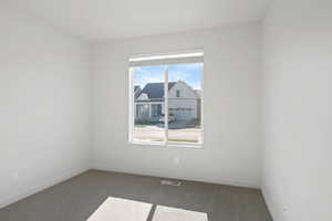 Spare room featuring baseboards, visible vents, and carpet floors