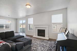 Living room featuring visible vents, baseboards, wood finished floors, and a fireplace with raised hearth