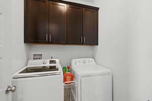 Washroom featuring cabinet space, independent washer and dryer, and tile patterned flooring