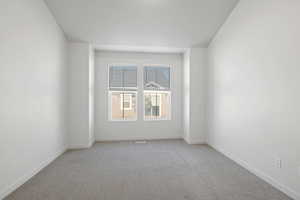 Carpeted empty room featuring baseboards