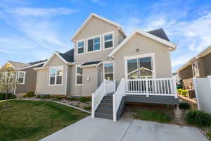 View of front of home featuring stucco siding, a front lawn, and central AC unit