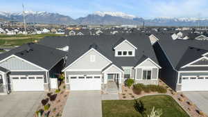 View of front of home with stone siding, a mountain view, a residential view, and concrete driveway