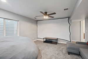 Carpeted bedroom with baseboards, a ceiling fan, and visible vents