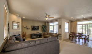 Living area featuring light tile patterned floors, baseboards, recessed lighting, and ceiling fan