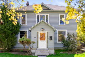View of front of property with a chimney and roof with shingles