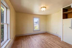 Unfurnished room featuring hardwood / wood-style floors, baseboards, and a wealth of natural light