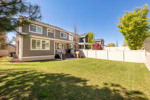 Rear view of property with fence and a yard