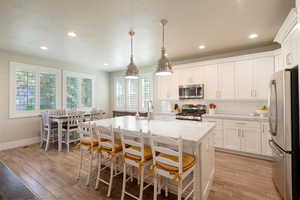 Kitchen with decorative backsplash, a wealth of natural light, appliances with stainless steel finishes, and light beautiful floors