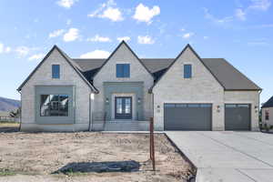 French country style house with french doors, driveway, a garage, and stone siding