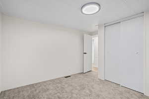 Unfurnished bedroom featuring a closet, visible vents, and carpet