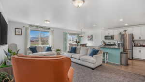 Living room featuring wood finished floors, an inviting chandelier, and recessed lighting
