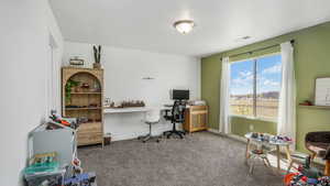 Carpeted office with baseboards and visible vents