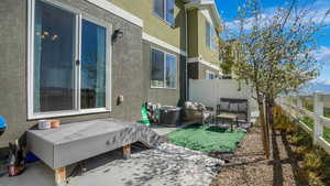 Exterior space with a patio, central air condition unit, a fenced backyard, and stucco siding