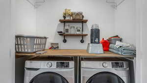 Washroom with washer and clothes dryer and laundry area