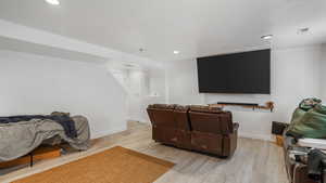 Cinema with light wood finished floors, baseboards, and visible vents