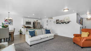 Living room with visible vents, recessed lighting, baseboards, dark wood-style floors, and a notable chandelier