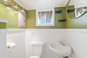 Bathroom featuring toilet, a sink, and electric panel