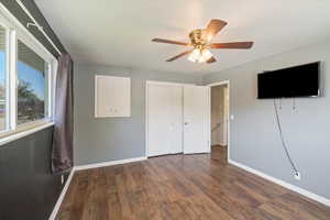 Unfurnished bedroom with ceiling fan, baseboards, wood finished floors, and a closet