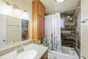 Bathroom featuring shower / tub combo, vanity, and toilet