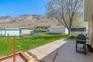 View of yard with fence, a patio area, a mountain view, and a trampoline