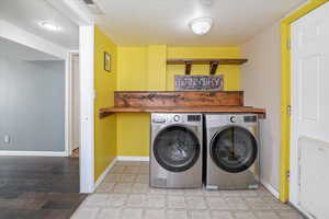 Laundry area featuring washing machine and clothes dryer, laundry area, visible vents, and baseboards