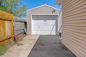 Garage with fence and aphalt driveway