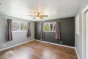 Unfurnished room with ceiling fan, baseboards, wood-type flooring, and visible vents