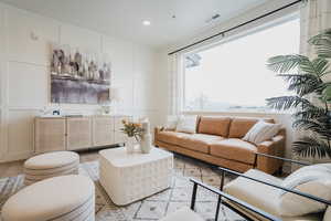 Model Home PicsLiving room featuring a decorative wall, light wood-style floors, visible vents, and recessed lighting