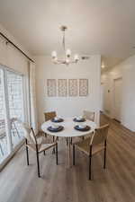 Model Home PicsDining room with an inviting chandelier, wood finished floors, visible vents, and baseboards