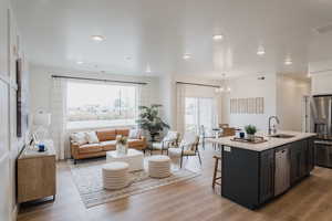 Model Home PicsKitchen featuring a sink, a chandelier, a kitchen bar, appliances with stainless steel finishes, and open floor plan