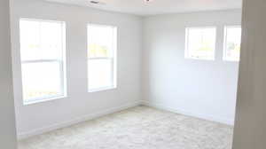 Spare room featuring baseboards and carpet