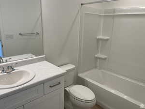 Bathroom with shower / washtub combination, toilet, and vanity