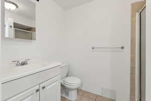 Bathroom with visible vents, tile patterned floors, a shower with door, and toilet