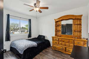 Bedroom featuring a ceiling fan, baseboards, and dark wood finished floors