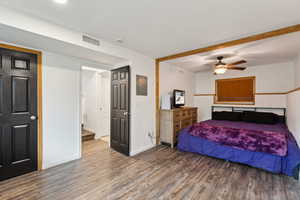 Bedroom featuring wood finished floors, visible vents, a ceiling fan, and baseboards