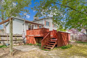 Back of house with fence, stairway, and a deck