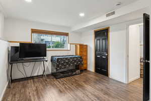 Living area featuring recessed lighting, wood finished floors, visible vents, and baseboards
