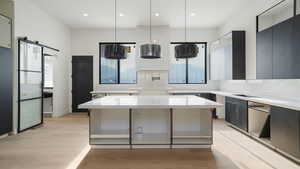 Progress pictures, 7/11/25Kitchen featuring plenty of natural light, backsplash, modern cabinets, light wood-type flooring, and recessed lighting