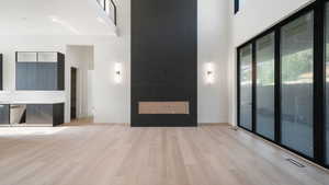 Progress pictures, 7/11/25: Unfurnished living room with healthy amount of natural light, a high ceiling, and light wood-style floors