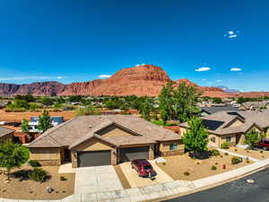 View of front of property with an attached garage, a mountain view, stone siding, and driveway