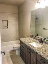Bathroom featuring shower / bathing tub combination, vanity, and toilet