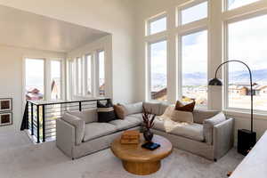Carpeted living area with a mountain view and a healthy amount of sunlight