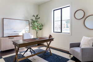 Home office featuring baseboards, wood finished floors, and radiator