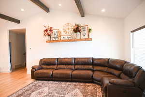 Living room featuring recessed lighting, wood finished floors, vaulted ceiling with beams, and baseboards