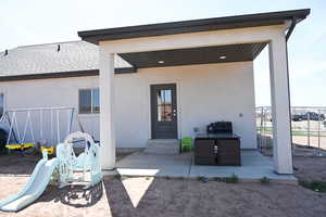 Exterior space with stucco siding, fence, a patio, and entry steps