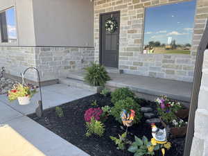 Entrance to property with stone siding and stucco siding