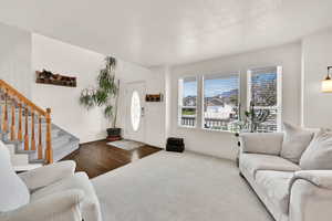 Carpeted living area with baseboards and stairway