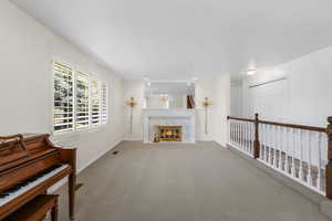 Living room featuring baseboards, carpet floors, and a high end fireplace